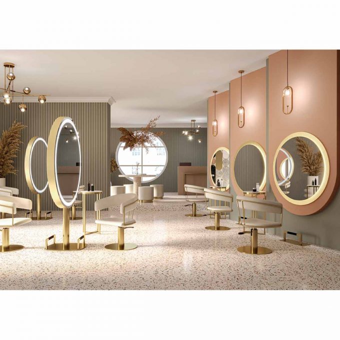 salon de coiffure avec grands miroirs ronds sur pieds et muraux avec fauteuils enveloppant structure tubulaire en métal couleur or et pied rond doré