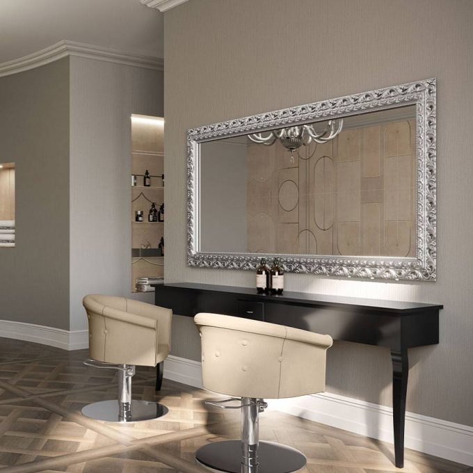 ambiance baroque revisité par les temps modernes, une console en bois laqué noir et un grand miroir avec un cadre en bois argenté et deux fauteuils d'époque